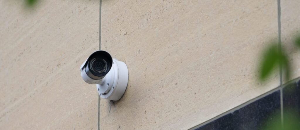 Modern CCTV camera mounted on a city building wall for security monitoring.
